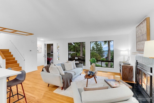 11214 80th Ave NE, Kirkland, WA 98034 - living room with stairs, light wood-style flooring, and a fireplace with flush hearth