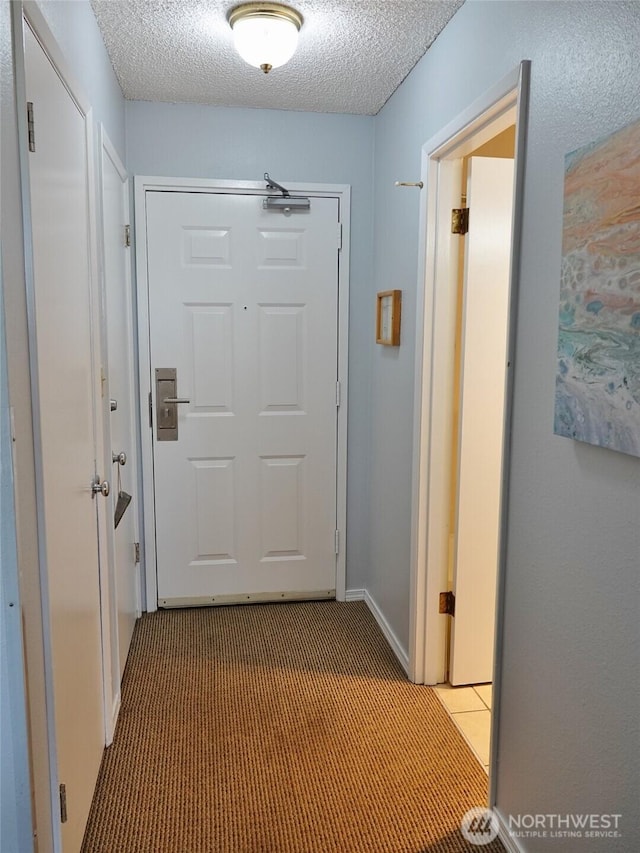 615 Ocean Shores Blvd NW Unit 210, Ocean Shores, WA 98569 - hallway featuring carpet and a textured ceiling