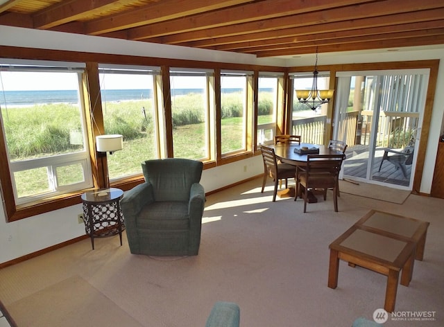 1407 Ocean Shores Blvd SW Unit 1N-I, Ocean Shores, WA 98569 - sunroom / solarium featuring view of water and beach, a chandelier, beamed ceiling, and carpet