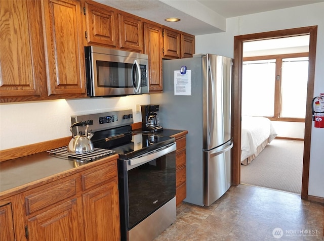 1407 Ocean Shores Blvd SW Unit 1N-I, Ocean Shores, WA 98569 - kitchen with appliances with stainless steel finishes, brown cabinetry, and light colored carpet