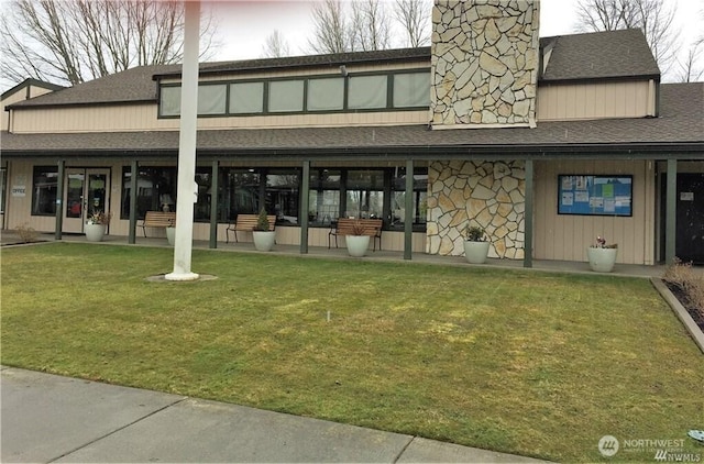 3611 I St NE Unit 291, Auburn, WA 98002 - rear view of house with a shingled roof, stone siding, a yard, and a chimney
