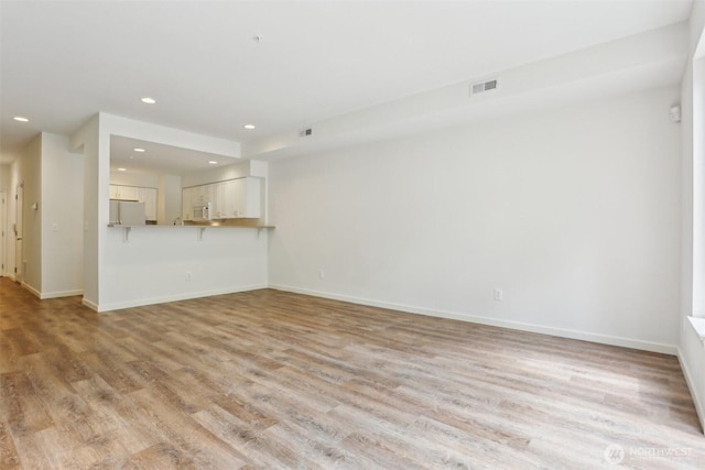 21616 9th Ave SE Unit C-105, Bothell, WA 98021 - unfurnished living room featuring recessed lighting and light wood finished floors