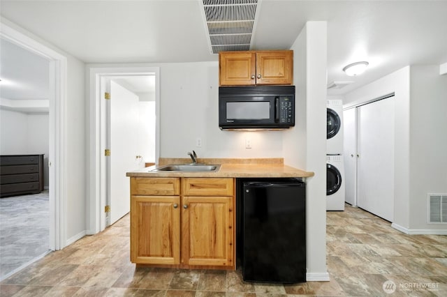 521 S Park St, Walla Walla, WA 99362 - kitchen featuring black appliances, stacked washing machine and dryer, light countertops, and stone finish flooring