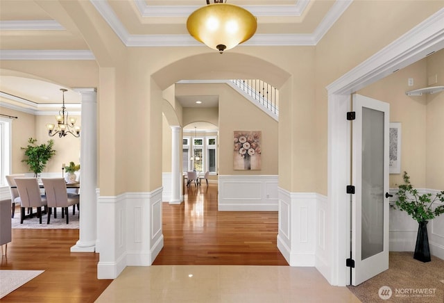14248 SE Allen Rd, Bellevue, WA 98006 - entryway featuring arched walkways, wood finished floors, a chandelier, ornamental molding, and a wainscoted wall