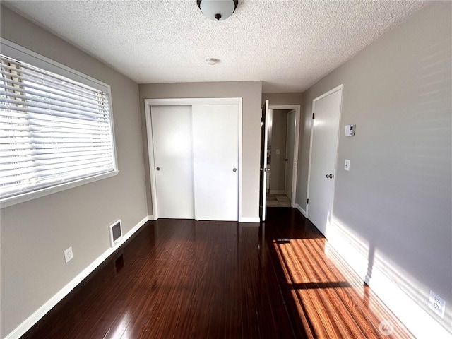1221 E 63rd St, Tacoma, WA 98404 - unfurnished bedroom featuring a closet, a textured ceiling, and wood finished floors