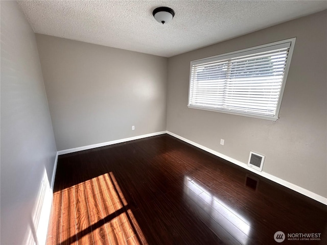 1221 E 63rd St, Tacoma, WA 98404 - spare room featuring dark wood-style flooring and a textured ceiling