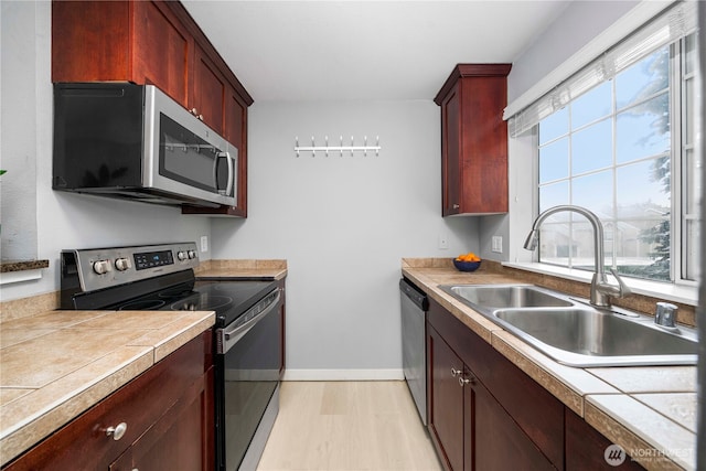 1839 S 286th Ln Unit S-201, Federal Way, WA 98003 - kitchen with appliances with stainless steel finishes, reddish brown cabinets, light wood-type flooring, and tile counters