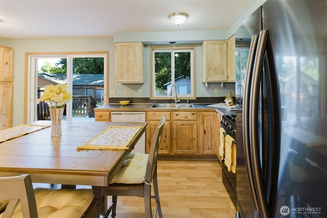 7601 Greenridge Loop SW, Olympia, WA 98512 - kitchen featuring freestanding refrigerator, light brown cabinetry, light wood-type flooring, black gas stove, and dark countertops