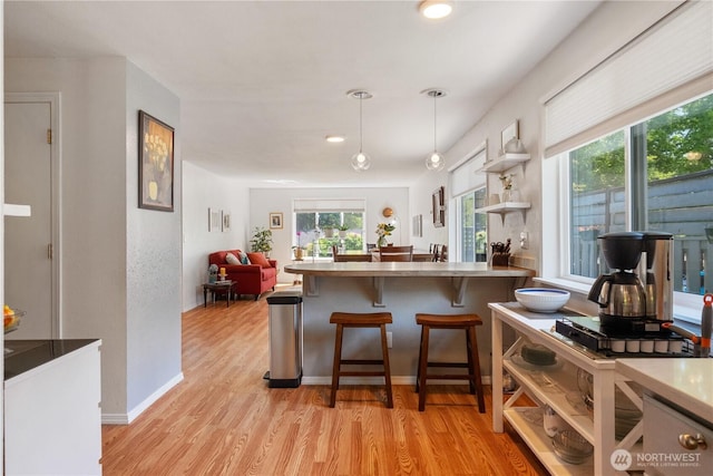 717 Cushing St SW, Olympia, WA 98502 - kitchen with light wood finished floors, plenty of natural light, pendant lighting, a breakfast bar, and recessed lighting