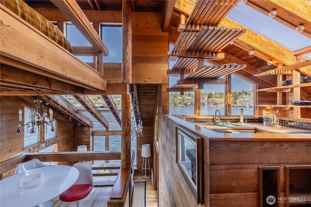 3123 Fairview Ave E Unit 2, Seattle, WA 98102 - kitchen featuring wooden walls, wood finished floors, a water view, open shelves, and a wood ceiling with exposed beams