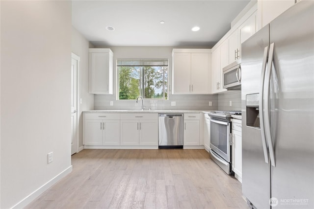 4239 NE 3rd Ln, Renton, WA 98059 - kitchen featuring stainless steel appliances, tasteful backsplash, white cabinetry, light wood finished floors, and recessed lighting