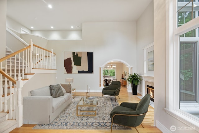 14691 NE 16th St, Bellevue, WA 98007 - living room with arched walkways, wood finished floors, stairway, a towering ceiling, and recessed lighting