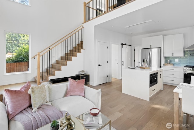 10520 NE 111th Pl, Kirkland, WA 98033 - living room with light wood-style flooring, a towering ceiling, and stairway