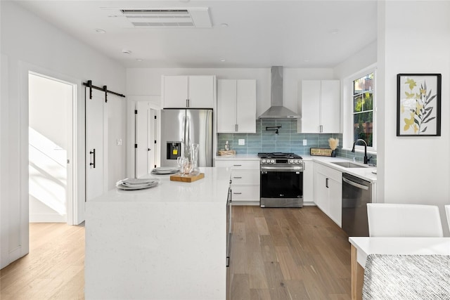 10520 NE 111th Pl, Kirkland, WA 98033 - kitchen with appliances with stainless steel finishes, wall chimney range hood, light wood-style flooring, and tasteful backsplash