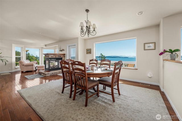 1223 Rainier Ln, Oak Harbor, WA 98277 - dining space featuring plenty of natural light, dark wood finished floors, a fireplace, and a chandelier