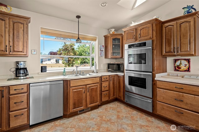 1223 Rainier Ln, Oak Harbor, WA 98277 - kitchen featuring appliances with stainless steel finishes, a warming drawer, lofted ceiling, brown cabinetry, and hanging light fixtures