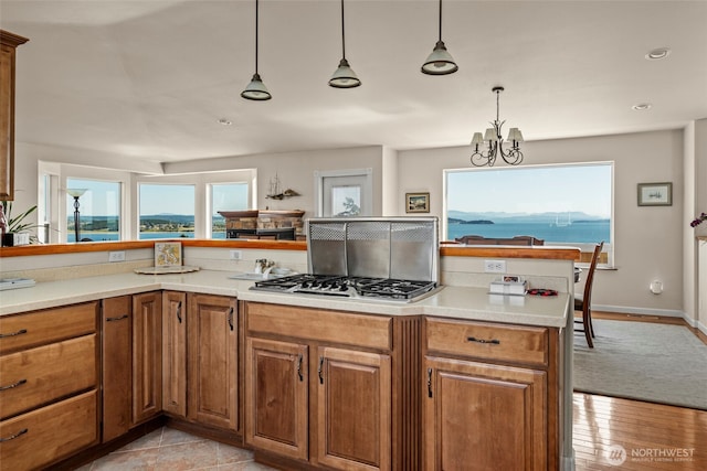 1223 Rainier Ln, Oak Harbor, WA 98277 - kitchen with stainless steel gas cooktop, brown cabinets, a chandelier, light countertops, and recessed lighting