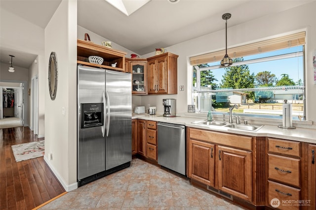 1223 Rainier Ln, Oak Harbor, WA 98277 - kitchen featuring appliances with stainless steel finishes, brown cabinets, vaulted ceiling, and light countertops