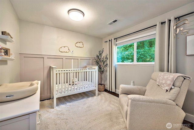 14305 109th Ave NE, Kirkland, WA 98034 - bedroom featuring a decorative wall, a nursery area, wood finished floors, and wainscoting