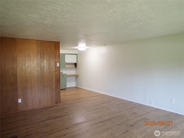 502504 4th St, Hoquiam, WA 98550 - spare room featuring wood finished floors, a textured ceiling, and wooden walls
