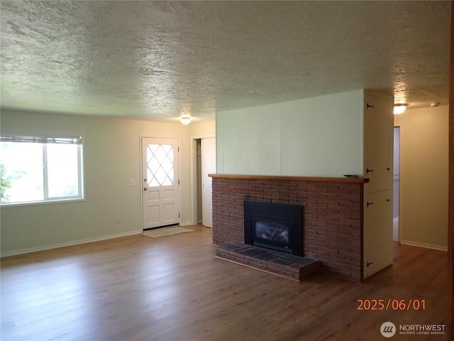 502504 4th St, Hoquiam, WA 98550 - unfurnished living room with a textured ceiling, wood finished floors, and a fireplace