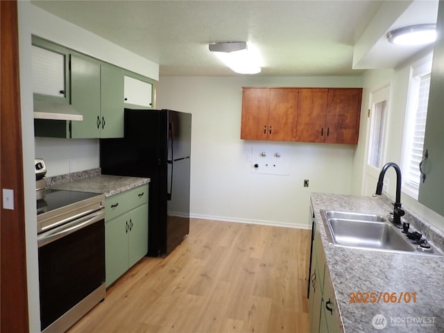 502504 4th St, Hoquiam, WA 98550 - kitchen with stainless steel range with electric cooktop, under cabinet range hood, freestanding refrigerator, light wood-style flooring, and green cabinets