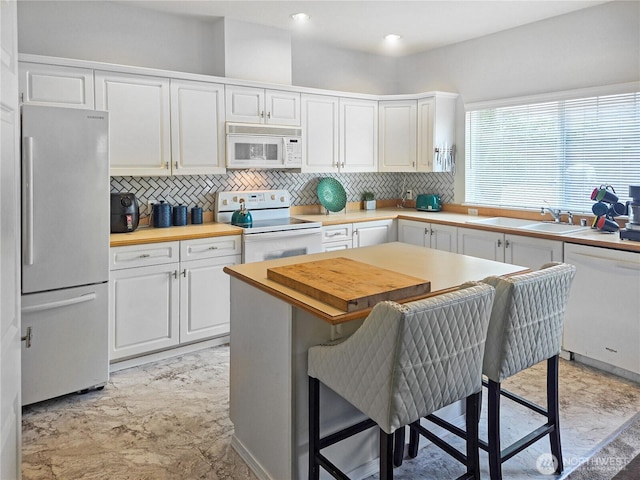 503 S 47th St Unit 11F, Renton, WA 98055 - kitchen featuring white appliances, butcher block counters, white cabinets, tasteful backsplash, and recessed lighting