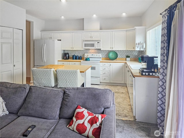 503 S 47th St Unit 11F, Renton, WA 98055 - kitchen featuring white appliances, open floor plan, backsplash, and white cabinetry