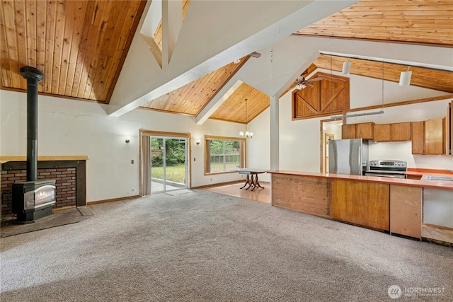 1810 Casassa Rd, Cle Elum, WA 98922 - unfurnished living room with high vaulted ceiling, carpet floors, a wood stove, ceiling fan, and a wood ceiling with exposed beams