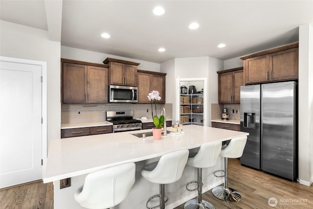 20821 98th Pl S, Kent, WA 98031 - kitchen with stainless steel appliances, tasteful backsplash, light countertops, wood finished floors, and recessed lighting