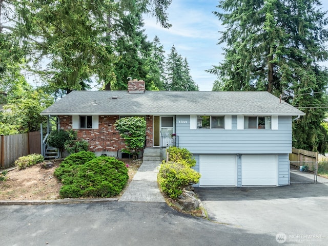 1847 N 183rd St, Shoreline, WA 98133 - view of front facade featuring an attached garage, a chimney, driveway, a shingled roof, and brick siding