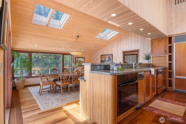 2247 Northshore Rd, Bellingham, WA 98226 - kitchen with a skylight, black oven, light wood-type flooring, a peninsula, and lofted ceiling