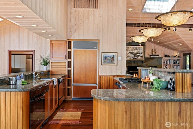 2247 Northshore Rd, Bellingham, WA 98226 - kitchen with paneled refrigerator, wood walls, oven, brown cabinetry, and dark wood-style flooring