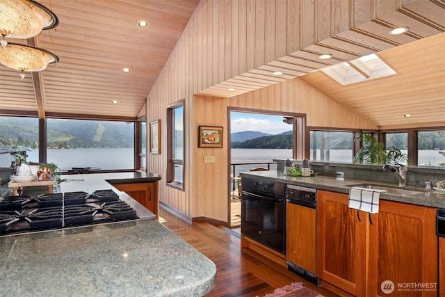 2247 Northshore Rd, Bellingham, WA 98226 - kitchen featuring stainless steel gas stovetop, oven, vaulted ceiling, dark wood-style flooring, and brown cabinetry