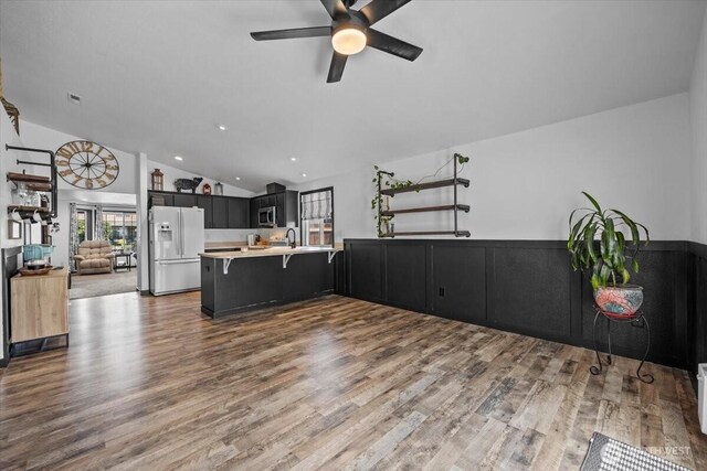 8308 Langara Dr, Pasco, WA 99301 - kitchen with white refrigerator with ice dispenser, stainless steel microwave, open floor plan, a peninsula, and lofted ceiling