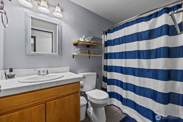 8308 Langara Dr, Pasco, WA 99301 - full bathroom featuring a textured wall, vanity, and a shower with curtain