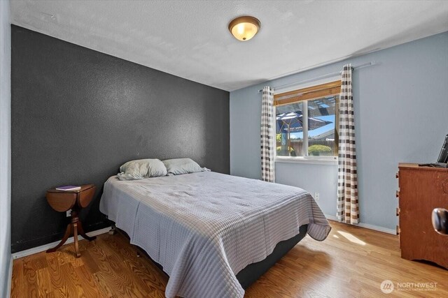 8308 Langara Dr, Pasco, WA 99301 - bedroom with wood finished floors and a textured wall