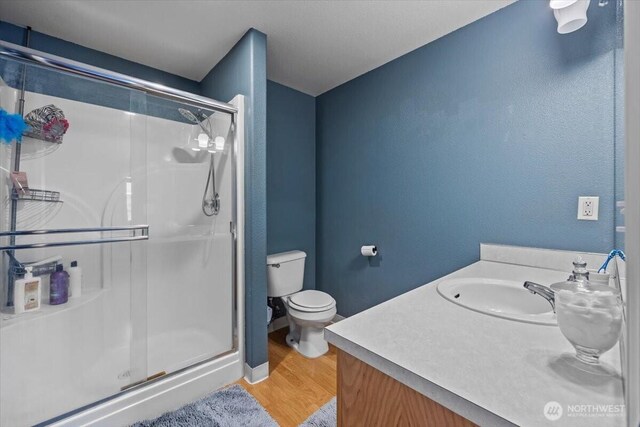 8308 Langara Dr, Pasco, WA 99301 - bathroom with a stall shower, wood finished floors, and vanity