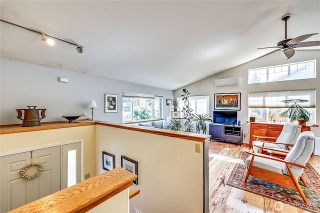 4243 Holcomb St, Port Townsend, WA 98368 - living room with vaulted ceiling, ceiling fan, light wood finished floors, rail lighting, and a wall mounted air conditioner
