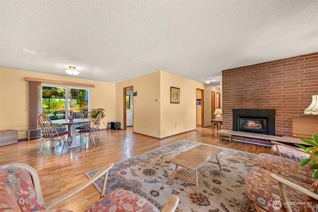 507 Lyla Ln, Bellingham, WA 98225 - living area featuring a textured ceiling, wood finished floors, and a brick fireplace