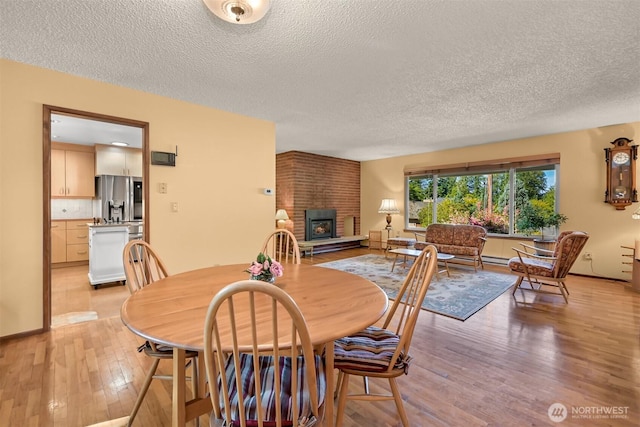 507 Lyla Ln, Bellingham, WA 98225 - dining space featuring a textured ceiling, light wood-style floors, and a fireplace