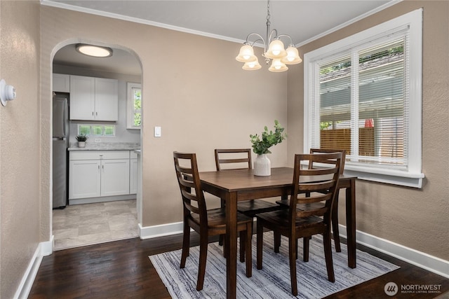 10812 2nd Ave S, Seattle, WA 98168 - dining area with crown molding, dark wood-style flooring, arched walkways, healthy amount of natural light, and a textured wall