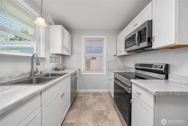 10812 2nd Ave S, Seattle, WA 98168 - kitchen with appliances with stainless steel finishes, light countertops, white cabinets, and pendant lighting