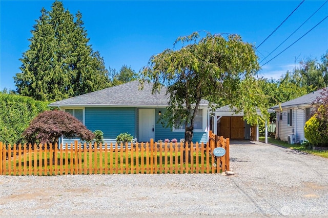 10812 2nd Ave S, Seattle, WA 98168 - view of front of house featuring a fenced front yard, a carport, driveway, and roof with shingles