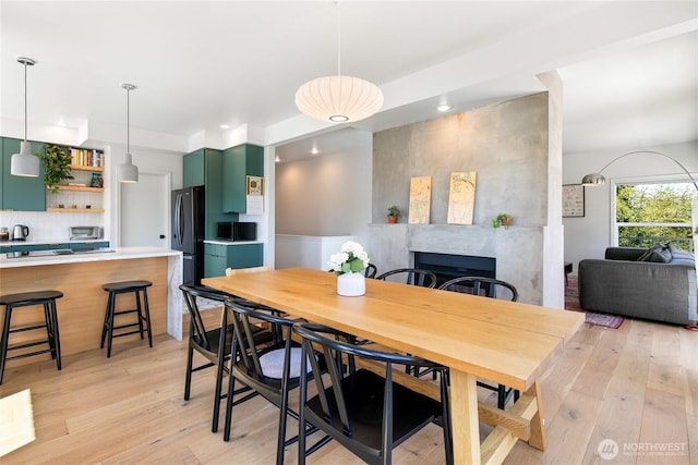 600 SW Cloverdale St, Seattle, WA 98106 - dining space featuring light wood finished floors, a tile fireplace, and recessed lighting