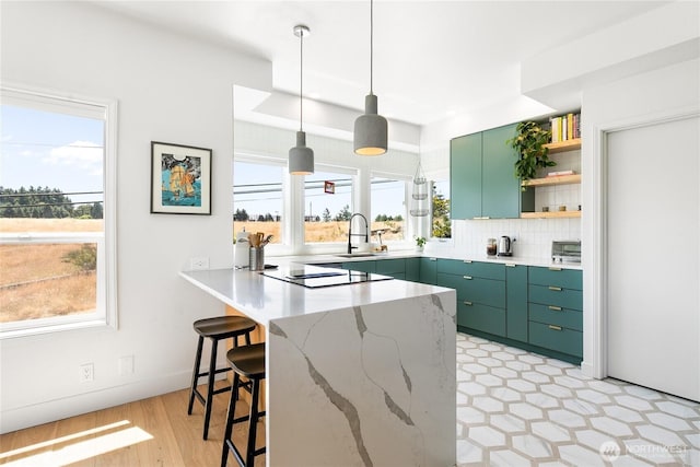600 SW Cloverdale St, Seattle, WA 98106 - kitchen featuring green cabinetry, a peninsula, black electric cooktop, open shelves, and a kitchen bar