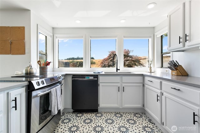 600 SW Cloverdale St, Seattle, WA 98106 - kitchen with stainless steel appliances, healthy amount of natural light, white cabinetry, light countertops, and recessed lighting