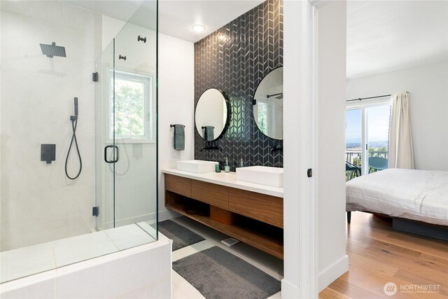 600 SW Cloverdale St, Seattle, WA 98106 - bathroom with a stall shower, double vanity, connected bathroom, and wood finished floors