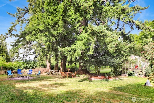 8597 Harborview Rd, Blaine, WA 98230 - view of green lawn with a greenhouse, an outdoor structure, and view of wooded area