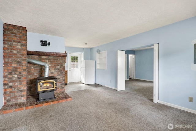 8597 Harborview Rd, Blaine, WA 98230 - unfurnished living room with a wood stove, carpet, and a textured ceiling